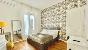 A bedroom with a bed, a mirror, a desk, and a chair.