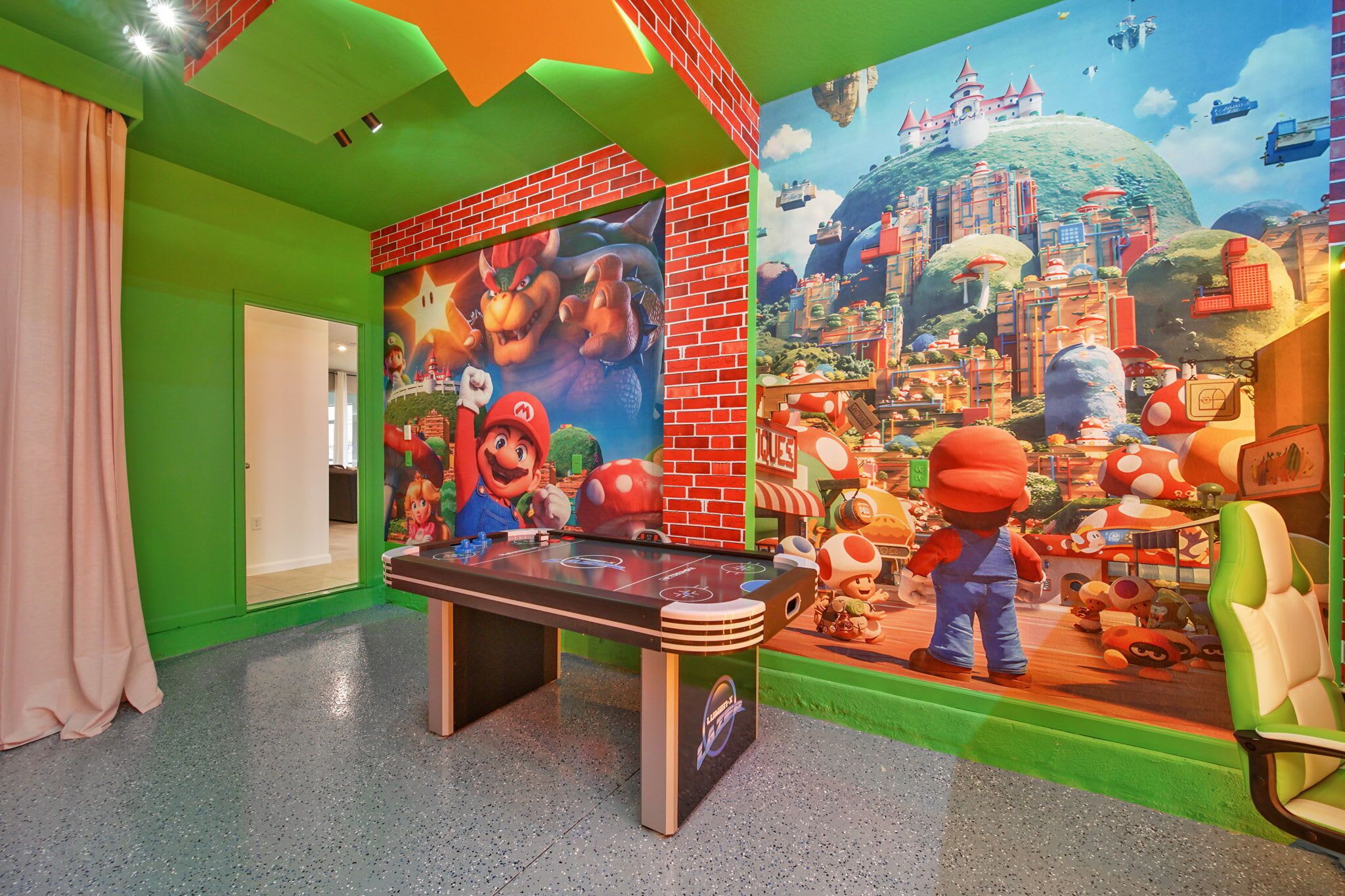 Habitación temática de Mario con mesa de billar, paredes verdes y un mural de Mario y Luigi.