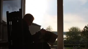 A person sitting on a bench reading a book.