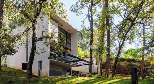 A modern house with a spacious outdoor area, a covered patio, and a well-maintained garden.