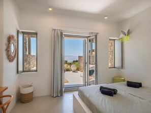 A bedroom with a bed, a window, and a view of the outdoors.
