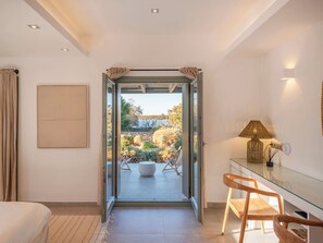 A modern bedroom with a glass door leading to an outdoor patio area.