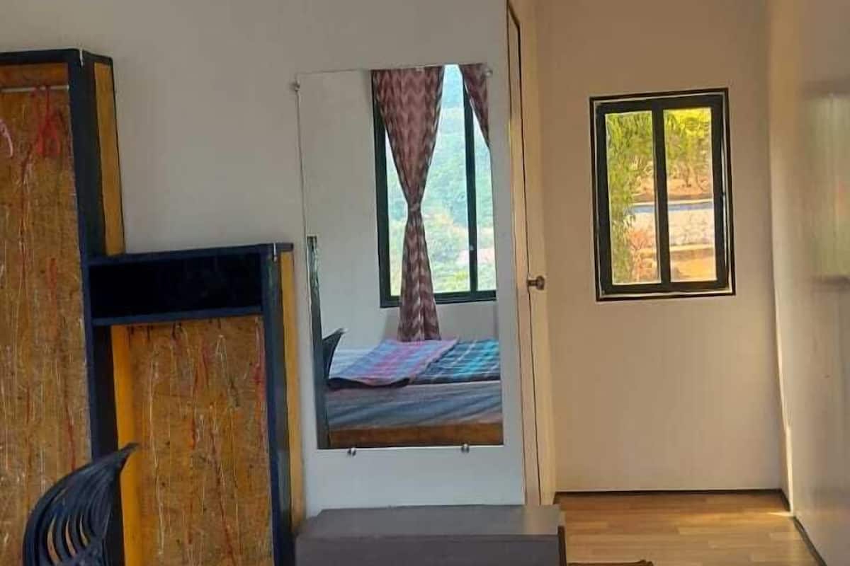 A bedroom with a bed, a ceiling fan, a window, and a view of the outdoors.