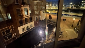 Ein nächtlicher Blick auf eine Stadtlandschaft mit Gebäuden, einem Kanal und Fahrrädern.