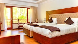 A hotel room with a large bed, a desk, and a chair. - Legacy Hotel Alchi (Alchi)