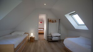 A bedroom with two wooden beds, a skylight, and a skylight.