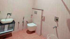 A bathroom with a wooden ceiling, a white sink, a toilet, and a shower. - The Shyama Grand Regency Ayodhya (Ayodhya)