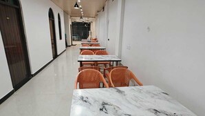 A long corridor with tables and chairs, a wooden ceiling, and a tiled floor. - The Shyama Grand Regency Ayodhya (Ayodhya)
