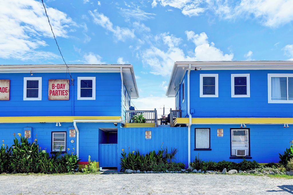 A blue building with a sign for B-day parties and a parking sign.