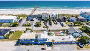 A coastal residential area with beachfront properties, a pier, and a parking lot.