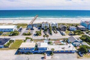 A coastal residential area with beachfront properties, a pier, and a parking lot.