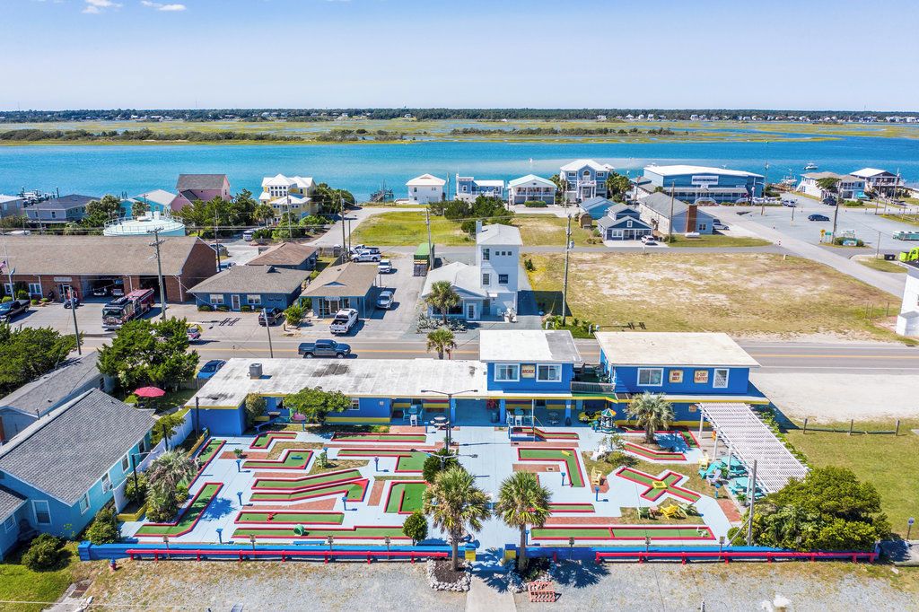 A coastal town with a marina, residential buildings, and a maze-like park area.
