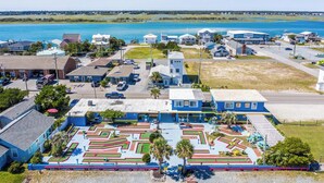 A coastal town with a marina, residential buildings, and a maze-like park area.