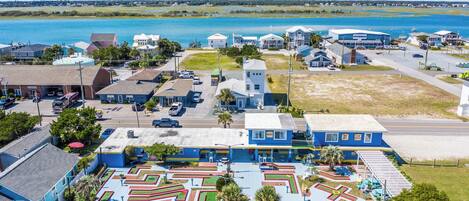 A coastal town with a marina, residential buildings, and a maze-like park area.