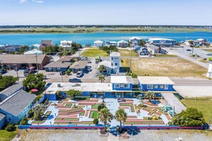 A coastal town with a marina, residential buildings, and a maze-like park area.