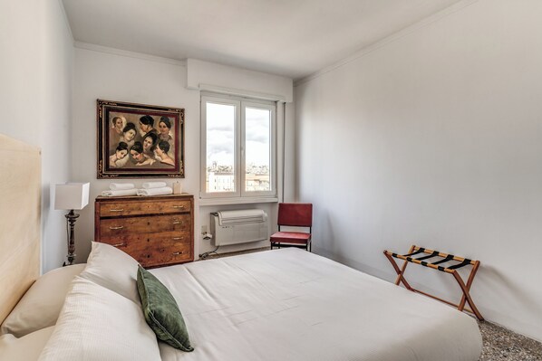 Un dormitorio con cama, cómoda, silla y ventana con vistas.