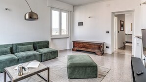 A modern living room with a green sofa, a coffee table, and a wooden cabinet. - Amazing Metro Piramide Station (Roma)