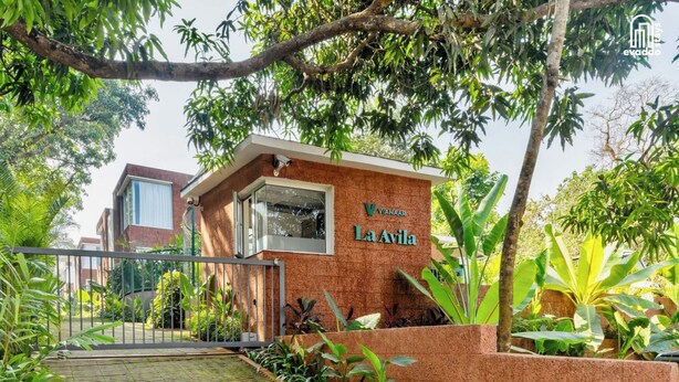 A building with a sign reading 'Vianaar La Avila' surrounded by lush greenery and a gated entrance. - SolVanya by evaddo stays (Siolim)