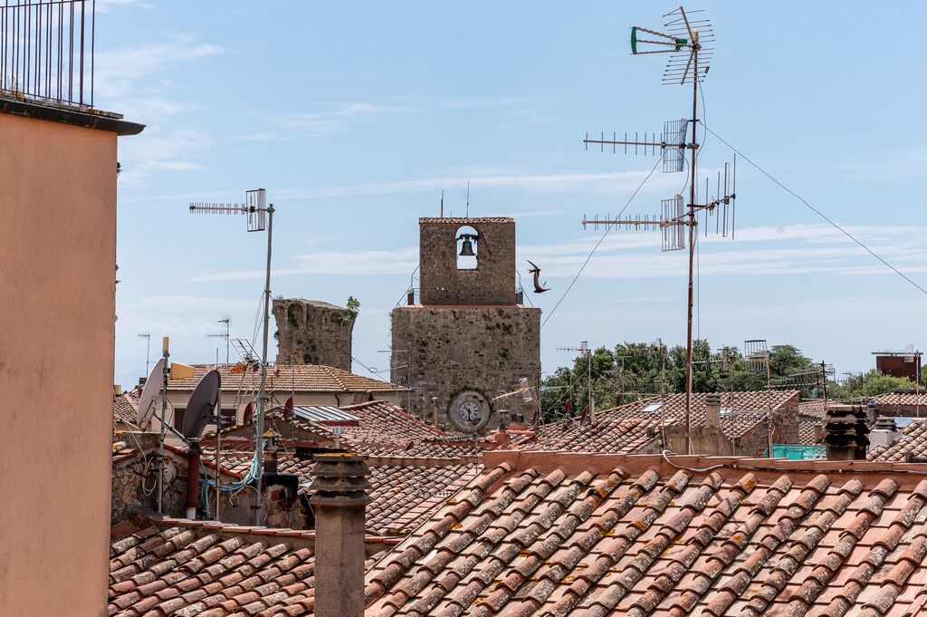 A historic building with a bell tower and multiple antennas on the roof.