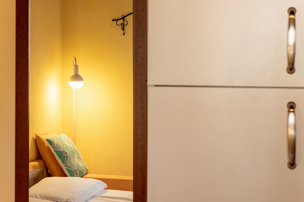 Une chambre à coucher avec un lit, une lampe de chevet et une armoire.