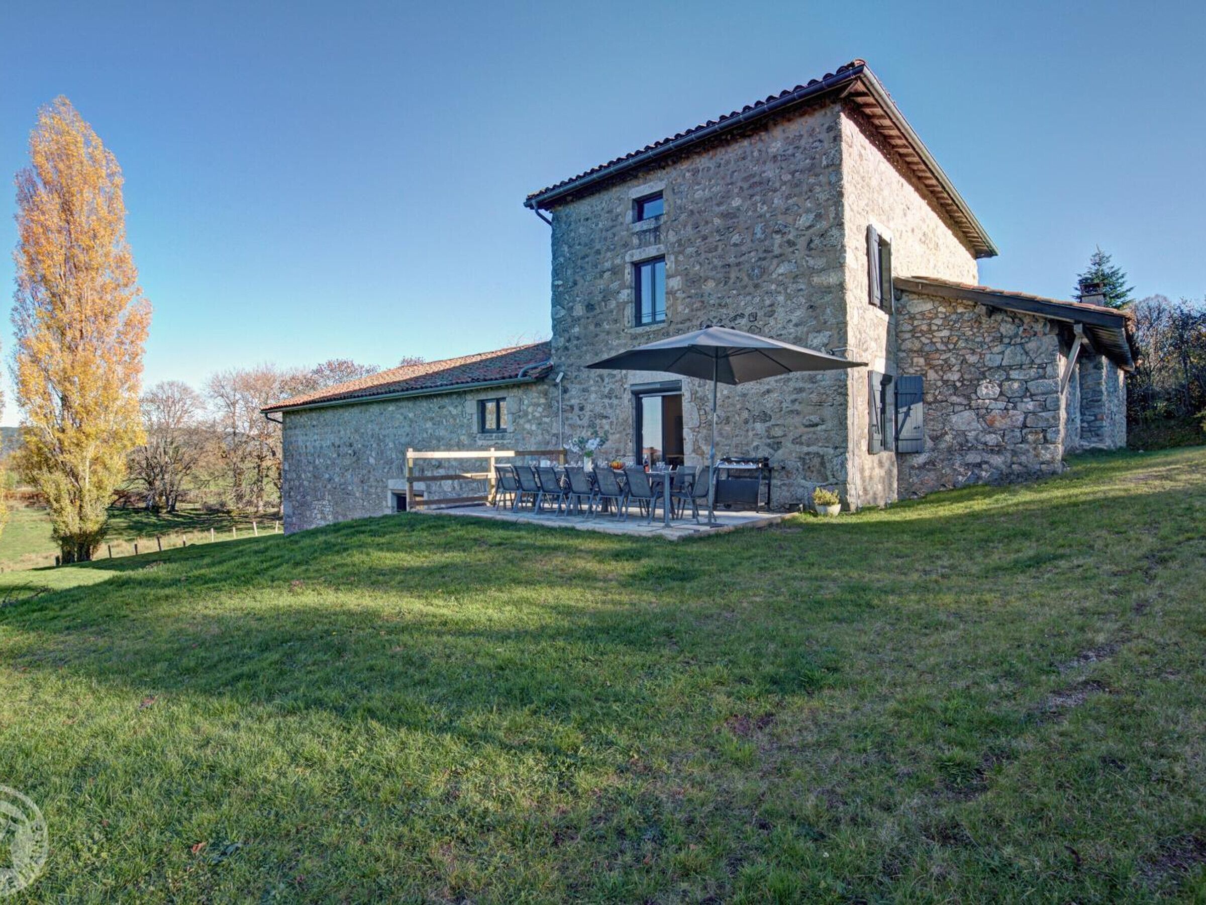 A stone house with a patio and outdoor seating area.