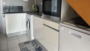 Cocina compacta con lavadora, horno y microondas.