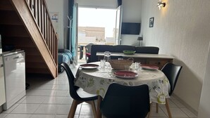 Un comedor con una mesa redonda, sillas y vistas al exterior.