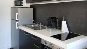 Una cocina moderna con microondas, cafetera, fregadero y estufa.