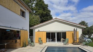 A modern house with a swimming pool, wooden deck, and a covered patio area. - Spacious house in Château-l'Évêque with 5 bedrooms and a game room (Château-l'Évêque)