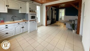 A spacious kitchen with white cabinets, a wooden ceiling, and a tiled floor. - Rustic cottage in Vendée Marshes, near beaches (Sallertaine)