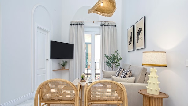 A living room with a sofa, two wicker chairs, a TV, a lamp, and a window with curtains. - Cozy 3BD in Seville Center. Alfalfa (Seville)