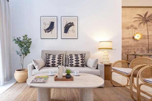 A modern living room with a sofa, coffee table, and chairs. There are two framed artworks on the wall, a potted plant, and a lamp. - Cozy 3BD in Seville Center. Alfalfa (Seville)