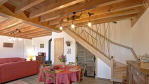 Un interior de madera con una mesa de comedor, sillas, un sofá y una escalera.