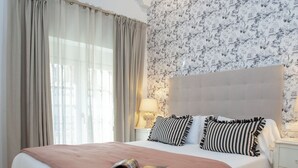 Une chambre à coucher avec un grand lit, une tête de lit et une table de chevet avec une lampe.