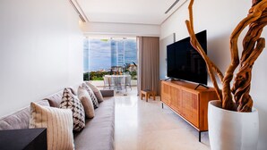 Una sala de estar moderna con un sofá, televisor y un mueble de madera.