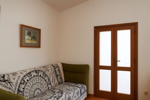 Appartement, uitzicht op tuin | Woonruimte | Een 32-inch flatscreentelevisie met kabelzenders