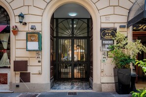 En hotelindgang med et sort gelænder, et skilt med 'Hotel Orbis' og et skilt for 'Parenti B&B'.