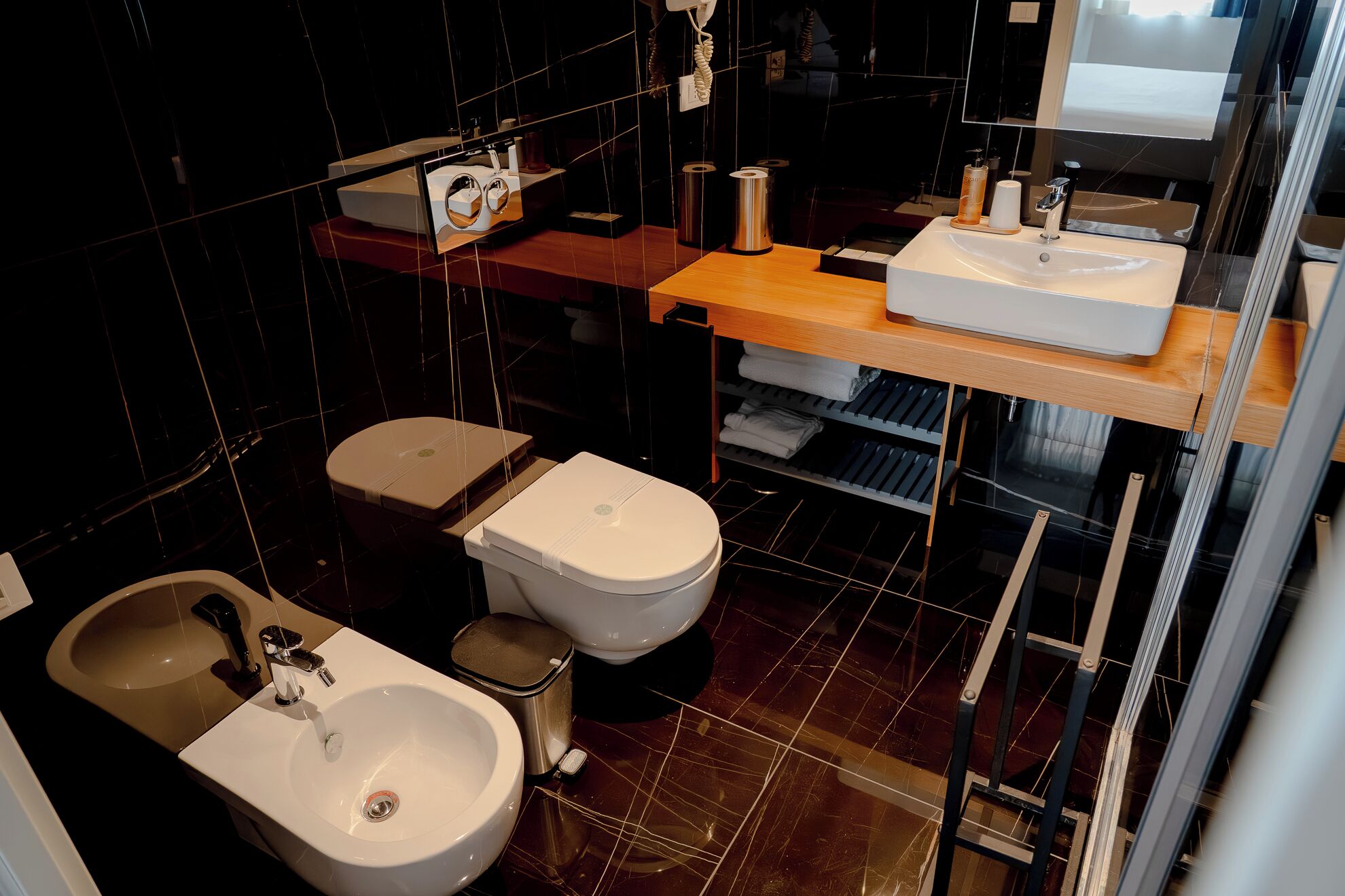 A modern bathroom with a bidet, a sink, and a toilet.