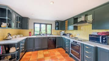 A modern kitchen with dark cabinets, a tiled backsplash, and a built-in oven.