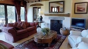 Una sala de estar acogedora con chimenea, televisor y asientos cómodos.