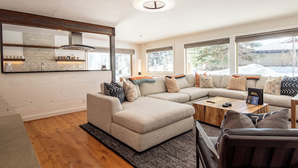 A modern living room with a sectional sofa, a coffee table, and a fireplace. - Hulen Way Home - Newly Remodeled Home with Trails Right Out the Front Door (Ketchum)
