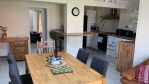 Ett kompakt bostadsutrymme med matplats, kök och sittgrupp.