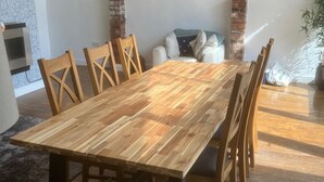Ein Essbereich mit Holztisch und -stühlen, einer Ziegelwand und einer Couch.