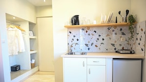 A compact kitchen with a countertop, a sink, and a small refrigerator. - Cozy Studio 2 (Malia)