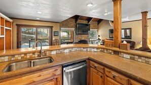 A kitchen with a granite countertop, stainless steel sink, and wooden cabinets. - Summer Resort Access, Hiking/Fishing, Hot Tub/Pool! (Durango)
