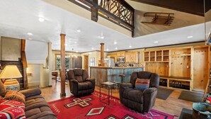 A spacious living area with a high ceiling, wooden beams, and a cozy fireplace. - Summer Resort Access, Hiking/Fishing, Hot Tub/Pool! (Durango)