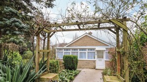 A house with a conservatory, a garden path, and a wooden gate. - Crown Farm (Wisbech)