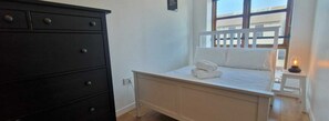 Cozy retreat with a single bed, dresser, and nightstand, perfect for a restful stay.