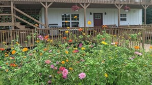 A two-story building with a balcony, a front door, and a staircase leading to the entrance. - The Inn at Beulah Farm - The Coop (Whitley City)