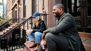 Three people sitting on a staircase outside a building with a wrought iron railing and a door with a decorative handle. - Outsite Chelsea - Work, Connect, Explore (New York)